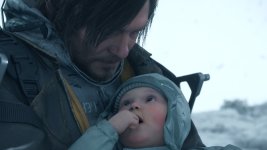 Auf dem Bild sieht man eine emotionale Szene aus einem Videospiel. Ein Charakter, der realistisch gestaltet ist, hält ein Baby in seinen Armen. Das Baby schaut mit großen Augen auf den Erwachsenen, während dieser mit einem nachdenklichen Ausdruck auf das Kind blickt. Die Umgebung wirkt kalt und rau, was durch den Schneefall und den grauen Himmel unterstrichen wird. Die Anziehsachen des Charakters scheinen wetterfest und robust zu sein, was auf schwierige Bedingungen hindeutet. Insgesamt vermittelt die Komposition eine Mischung aus Fürsorge und Dramatik.