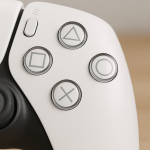 Das Bild zeigt eine Nahaufnahme eines Videospielcontrollers, auf dem sich vier charakteristische Tasten befinden. Diese Tasten sind in verschiedenen Formen dargestellt: ein Dreieck, ein Quadrat, ein Kreis und ein Kreuz. Der Controller hat ein elegantes Design in Schwarz und Weiß und der Fokus liegt auf den Tasten, die in einem glänzenden Finish gehalten sind. Im Hintergrund ist unscharf ein neutraler Farbton zu erkennen, der die Benutzeroberfläche des Controllers betont.