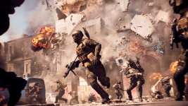 Das Bild zeigt eine intensive Kampfszene aus einem modernen Militär-Shooter. Soldaten in taktischer Ausrüstung rennen durch eine Stadt, während explosionsartige Zerstörungen im Hintergrund sichtbar sind. Gebäude brechen zusammen, und Rauch sowie Feuer dominieren die Szenerie, was eine dynamische und aufregende Atmosphäre schafft. Die Action scheint auf einem hohen technischen Niveau zu sein, mit Fokus auf realistische Effekte und Details.