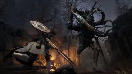 Das Bild zeigt eine spannende Kampfszene aus dem Spiel Lies of P. Im Vordergrund ist ein Charakter zu sehen, der mit einer großen, gezackten Waffe angreift. Der Charakter scheint sich in einer aktiven Position zu befinden und ist bereit, einen Gegner anzugreifen. Im Hintergrund steht ein groteskes, monsterähnliches Wesen, das mit langen Tentakeln ausgestattet ist und bedrohlich wirkt. Die Szenerie ist von dunkler, nebliger Atmosphäre geprägt, die eine düstere Stimmung erzeugt. Die Umgebung weist natürliche Elemente und möglicherweise Überreste einer zerstörten Stadt auf, was die dramatische Handlung des Spiels unterstreicht.