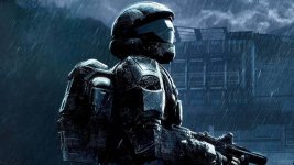 Auf dem Bild ist ein Soldat in einem futuristischen, dunklen Anzug zu sehen, der sich in einem regnerischen Szenario befindet. Der Soldat trägt einen Helm und hat eine Waffe in der Hand. Die Umgebung ist düster und erinnert an eine städtische Kulisse, möglicherweise inspiriert von der Welt der Halo-Spielreihe. Die Atmosphäre wirkt angespannt und geheimnisvoll, während der Soldat entschlossen und kampfbereit wirkt. Die gesamte Szene vermittelt ein Gefühl von Dramatik und Action, was die Verbindung zu einem aufregenden Gaming-Universum unterstreicht.