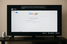 Das Bild zeigt einen Fernseher, auf dem die Homepage von Google geöffnet ist. Oben in der Bildschirmmitte ist ein Hinweis zu sehen, der informiert, dass die PS5 in sechs Minuten in den Ruhemodus wechseln wird, aufgrund der Energiespareinstellungen. Der Bildschirm ist hell und klar strukturiert, mit der typischen Google-Suchleiste in der Mitte. Am unteren Bildschirmrand sind Symbole zu sehen, die Optionen wie Neu laden, Zurück und Vergrößern anbieten. Der Hintergrund des Bildschirms hat einen sanften Farbton, und die gesamte Darstellung vermittelt einen technischen Eindruck, der die Funktionalität eines Webbrowsers auf der PS5 symbolisiert. Das Bild zeigt einen Fernseher, auf dem die Homepage von Google geöffnet ist. Oben in der Bildschirmmitte ist ein Hinweis zu sehen, der informiert, dass die PS5 in sechs Minuten in den Ruhemodus wechseln wird, aufgrund der Energiespareinstellungen. Der Bildschirm ist hell und klar strukturiert, mit der typischen Google-Suchleiste in der Mitte. Am unteren Bildschirmrand sind Symbole zu sehen, die Optionen wie Neu laden, Zurück und Vergrößern anbieten. Der Hintergrund des Bildschirms hat einen sanften Farbton, und die gesamte Darstellung vermittelt einen technischen Eindruck, der die Funktionalität eines Webbrowsers auf der PS5 symbolisiert.