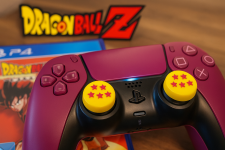 Das Bild zeigt einen pinken PS5-Controller mit auffälligen gelben Daumensticks, die das Design der Vier-Sterne-Dragonballs aus der beliebten Anime-Serie Dragon Ball Z imitieren. Im Hintergrund sind Verpackungen und Logos der Dragon Ball Z-Spiele zu sehen, was die Verbindung zur Franchise unterstreicht. Der Controller wirkt farbenfroh und einladend, wodurch er einen spielerischen und nerdigen Eindruck vermittelt.