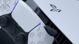 Das Bild zeigt eine PlayStation 5 Konsole in einem modernen Design, die mit einem PlayStation-Controller kombiniert ist. Die Konsole ist in einer eleganten weißen und schwarzen Farbgestaltung gehalten, die futuristisch wirkt. Die Controller sind ergonomisch geformt und bieten vielfältige Steuerungsmöglichkeiten für Spieler. Diese visuelle Kombination symbolisiert die aktuelle Gaming-Technologie und verweist auf die Diskussion über Preise und Zugänglichkeit in der Gaming-Welt.