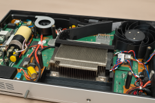 Das Bild zeigt das Innere einer modifizierten PlayStation 5, in der ein benutzerdefiniertes Gehäuse verwendet wurde. Man sieht verschiedene elektronische Komponenten, darunter das Mainboard, einen Kühler und Kabelverbindungen. Ein 3D-gedruckter Lüfter ist sichtbar, der für die Kühlung zuständig ist. Das Layout der Bauteile ist ordentlich angeordnet, um Platz zu sparen und eine kompakte Bauweise zu ermöglichen. Diese modifizierte Konsole bietet die Möglichkeit, die PS5 mobil zu nutzen, und zeigt die kreative Technik eines Modders, der eine tragbare Version der beliebten Spielekonsole erschaffen hat. Das Bild zeigt das Innere einer modifizierten PlayStation 5, in der ein benutzerdefiniertes Gehäuse verwendet wurde. Man sieht verschiedene elektronische Komponenten, darunter das Mainboard, einen Kühler und Kabelverbindungen. Ein 3D-gedruckter Lüfter ist sichtbar, der für die Kühlung zuständig ist. Das Layout der Bauteile ist ordentlich angeordnet, um Platz zu sparen und eine kompakte Bauweise zu ermöglichen. Diese modifizierte Konsole bietet die Möglichkeit, die PS5 mobil zu nutzen, und zeigt die kreative Technik eines Modders, der eine tragbare Version der beliebten Spielekonsole erschaffen hat.