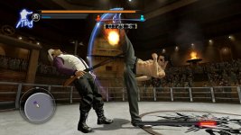 Das Bild zeigt eine dynamische Kampfszene aus dem Spiel Yakuza 0. Zwei Charaktere sind in einem Ring engagiert, wobei einer mit einem kräftigen Kick nach dem anderen schlägt, der scheinbar durch die Wucht des Angriffs zurückweicht. Der Angreifer trägt eine Sonnenbrille und hat ein markantes Tattoo auf seinem Arm, während der andere Charakter eine Waffe in der Hand hält. Im Hintergrund sind Zuschauer zu sehen, die das Geschehen beobachten. Die Atmosphäre ist intensiv und vermittelt den Eindruck eines spannenden Duells.