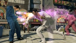 Das Bild zeigt eine actiongeladene Szene aus dem Spiel Yakuza 0, in der zwei Charaktere im Kampf verwickelt sind. Der Angreifer in einem weißen Anzug führt einen kraftvollen Schlag aus, während sein Gegner in einem karierten blauen Anzug darauf vorbereitet ist, ihn abzuwehren. Im Hintergrund sind die lebhaften Lichter und Plakate einer städtischen Umgebung zu sehen, die die Atmosphäre des Spiels unterstreichen. Die Grafik präsentiert detaillierte Charaktere und Animationen, die die Intensität der Auseinandersetzung hervorheben.