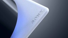 Das Bild zeigt einen Teil eines PS5-Controllers, der ansprechend aus einer nahen Perspektive aufgenommen wurde. Die Oberfläche ist strukturiert und besteht aus einem weißen Material, das durch einen bläulichen Lichtakzent erhellt wird. In der Ecke ist das Logo von Sony in taktiler Schrift zu erkennen. Der Hintergrund ist schlicht und sorgt dafür, dass der Fokus auf dem Controller liegt, was die moderne und stilvolle Gestaltung der PS5-Produktlinie betont. Das Bild zeigt einen Teil eines PS5-Controllers, der ansprechend aus einer nahen Perspektive aufgenommen wurde. Die Oberfläche ist strukturiert und besteht aus einem weißen Material, das durch einen bläulichen Lichtakzent erhellt wird. In der Ecke ist das Logo von Sony in taktiler Schrift zu erkennen. Der Hintergrund ist schlicht und sorgt dafür, dass der Fokus auf dem Controller liegt, was die moderne und stilvolle Gestaltung der PS5-Produktlinie betont.
