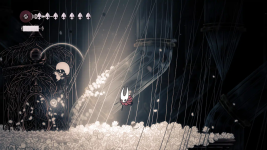 Das Bild zeigt eine düstere und atmosphärische Spielszene aus Hollow Knight: Silksong. In der Mitte des Geschehens sieht man eine kleine Figur, die mit einer Maske und einem Umhang versehen ist und durch eine von zarten, weißen Blüten umgebene Landschaft schwebt. Diese Blüten sind auf einem helleren Grund angeordnet, was einen Kontrast zur dunklen Umgebung bildet. Im Hintergrund zeichnen sich stilisierte, geschwungene Formen ab, die an filigrane Architektur erinnern, während dünne Linien und Lichtstrahlen eine geheimnisvolle Stimmung erzeugen. Die Bildkomposition vermittelt das Gefühl von Abenteuer und Entdeckung in einer fantasievollen Welt.