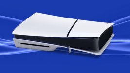 Das Bild zeigt eine PlayStation 5 Konsole, die auf einem einfarbigen blauen Hintergrund platziert ist. Die Konsole hat ein elegantes, modernes Design mit einer weißen Oberseite und einem schwarzen Unterteil. Die Konturen sind geschwungen und verleihen der Konsole ein futuristisches Aussehen. Es sind die verschiedenen Elemente der Konsole deutlich erkennbar, darunter die Anschlüsse an der Vorderseite. Der Hintergrund vermittelt einen sauberen und minimalistischen Eindruck, der die PlayStation 5 hervorhebt.