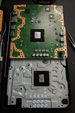 Das Bild zeigt das Innenleben einer PlayStation 5, das in zwei Teile aufgeteilt ist. Der obere Teil zeigt die Hauptplatine mit verschiedenen Bauteilen, während der untere Teil das Gehäuse oder die Kühlplatte darstellt. In der Mitte befindet sich der Bereich mit der Wärmeleitpaste, der mit feinen Rillen versehen ist, was auf die neuen Verbesserungen in der Kühlungstechnologie hinweist. Die gesamte Bauweise und Anordnung der Komponenten sind auf eine optimale Wärmeabführung sowie Stabilität ausgelegt.