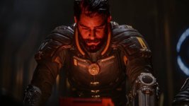 Das Bild zeigt einen männlichen Charakter mit dunklem, pflegeleichtem Haar und einem dichten Bart. Er trägt eine futuristische, dunkle Rüstung mit mehreren technischen Details und Symbolen, die auf seine Rolle als Soltari-Enforcer hinweisen. Sein Gesichtsausdruck wirkt konzentriert und nachdenklich, während er einen leuchtenden Gegenstand vor sich betrachtet. Die Umgebung ist düster und vermittelt eine geheimnisvolle Atmosphäre, die auf die Science-Fiction-Thematik des Spiels hinweist. Der Charakter sieht aus, als würde er sich mit einer wichtigen Mission befassen oder ein Rätsel lösen. Das Bild zeigt einen männlichen Charakter mit dunklem, pflegeleichtem Haar und einem dichten Bart. Er trägt eine futuristische, dunkle Rüstung mit mehreren technischen Details und Symbolen, die auf seine Rolle als Soltari-Enforcer hinweisen. Sein Gesichtsausdruck wirkt konzentriert und nachdenklich, während er einen leuchtenden Gegenstand vor sich betrachtet. Die Umgebung ist düster und vermittelt eine geheimnisvolle Atmosphäre, die auf die Science-Fiction-Thematik des Spiels hinweist. Der Charakter sieht aus, als würde er sich mit einer wichtigen Mission befassen oder ein Rätsel lösen.