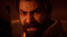 Das Bild zeigt einen intensiven Nahbereich eines männlichen Charakters mit einem markanten Bart und einem entschlossenen Ausdruck. Sein Gesichtsausdruck vermittelt Wut oder Entschlossenheit, während er direkt in die Kamera schaut. Der Hintergrund ist leicht verschwommen und strahlt eine düstere, rot-orangefarbene Atmosphäre aus, die eine bedrohliche Stimmung erzeugt. Diese visuelle Darstellung passt gut zu einem actionreichen, spannungsgeladenen Kontext, in dem der Charakter wahrscheinlich in einer kritischen Situation ist. Das Bild zeigt einen intensiven Nahbereich eines männlichen Charakters mit einem markanten Bart und einem entschlossenen Ausdruck. Sein Gesichtsausdruck vermittelt Wut oder Entschlossenheit, während er direkt in die Kamera schaut. Der Hintergrund ist leicht verschwommen und strahlt eine düstere, rot-orangefarbene Atmosphäre aus, die eine bedrohliche Stimmung erzeugt. Diese visuelle Darstellung passt gut zu einem actionreichen, spannungsgeladenen Kontext, in dem der Charakter wahrscheinlich in einer kritischen Situation ist.