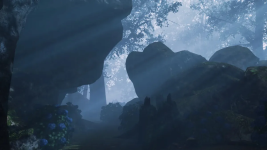 Das Bild zeigt eine mystische und düstere Waldlandschaft, in der sanfte Lichtstrahlen durch die Bäume fallen. Umgeben von großen, unregelmäßigen Felsen und dichter Vegetation, vermitteln die Elemente eine geheimnisvolle Atmosphäre. Der neblige Hintergrund verstärkt das Gefühl von Unheimlichkeit, während die Farben in verschiedenen Grüntönen und dem sanften Blau der Lichtstrahlen einen eindrucksvollen Kontrast bieten. Die Szene wirkt so, als könnte sie Teil eines spannenden Abenteuers oder Horrorspiels sein, was gut zu dem bevorstehenden Spielrelease von Shadow Corridor 2 passt.