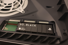 Das Bild zeigt eine Nahaufnahme des Innenraums einer PlayStation 5, in dem eine WD Black SN850P SSD installiert ist. Die SSD ist deutlich sichtbar und an einem speziellen Steckplatz positioniert. Um den Steckplatz herum sind Details des Gehäuses erkennbar, einschließlich eines Kühlgebläses, das zur Wärmeableitung beiträgt. Die Gesamtaufnahme vermittelt den Eindruck eines technologisch fortschrittlichen Systems, das für die Erweiterung des Speichers ausgelegt ist. Das Bild zeigt eine Nahaufnahme des Innenraums einer PlayStation 5, in dem eine WD Black SN850P SSD installiert ist. Die SSD ist deutlich sichtbar und an einem speziellen Steckplatz positioniert. Um den Steckplatz herum sind Details des Gehäuses erkennbar, einschließlich eines Kühlgebläses, das zur Wärmeableitung beiträgt. Die Gesamtaufnahme vermittelt den Eindruck eines technologisch fortschrittlichen Systems, das für die Erweiterung des Speichers ausgelegt ist.